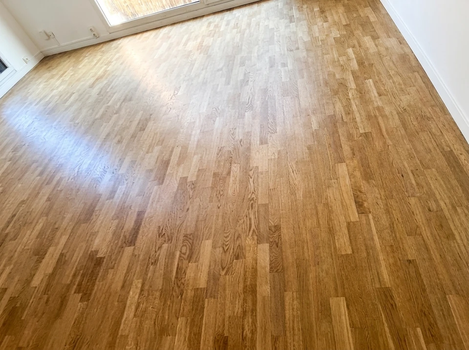 Pièce vide avec parquet en bois massif poncé et vitrifié, teinte miel dorée