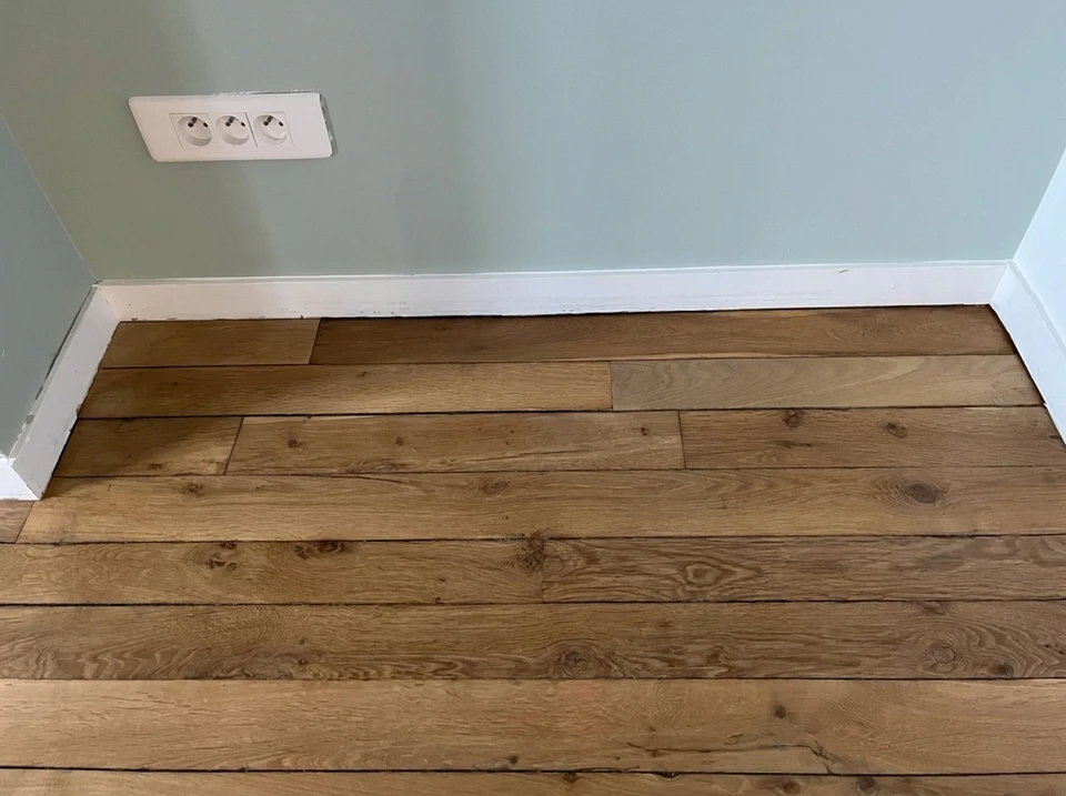 Intérieur résidentiel avec sol en parquet massif disposé en motif chevron ou point de Hongrie