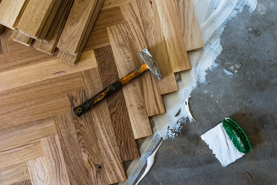 Parquet en bois massif aux tons chauds, planches rectangulaires disposées en motif brique