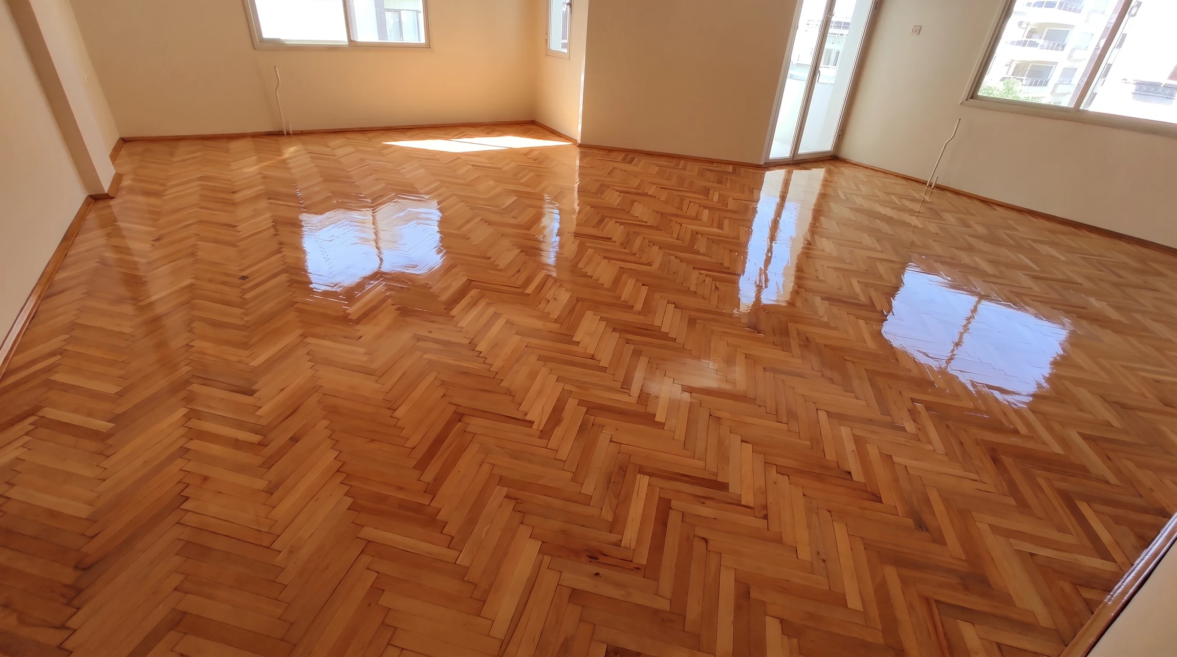 Intérieur résidentiel présentant un parquet en bois naturel disposé en motif chevron ou point de Hongrie