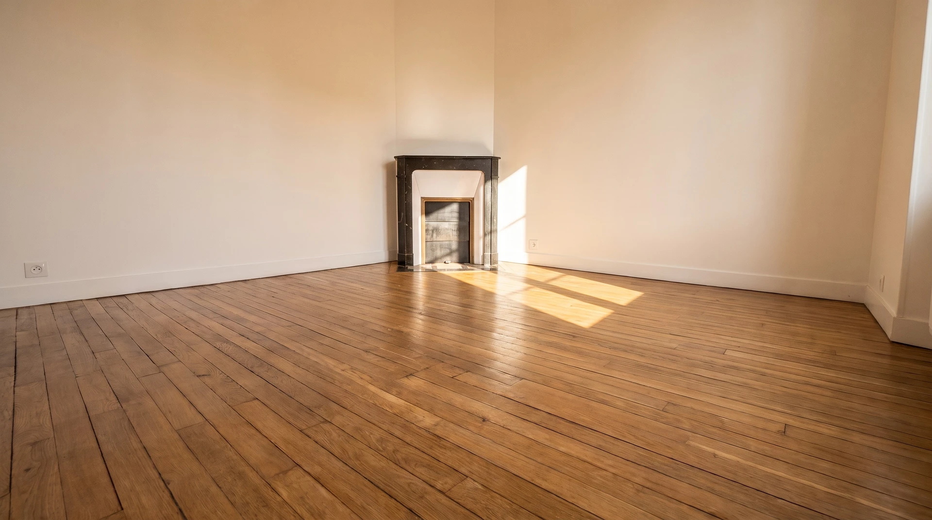 Pièce vide rénovée avec parquet en bois clair, murs blancs et plafond à poutres apparentes